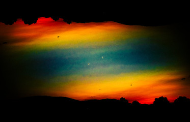 Silhouetted landscape against colorful sky