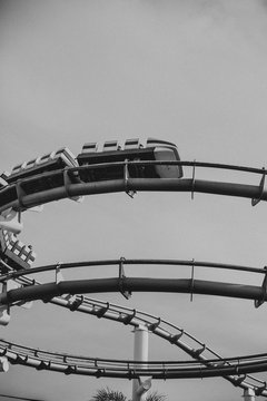 Roller coaster ride against sky helix black and white