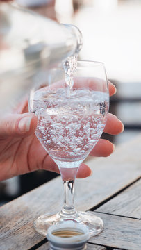 Close up woman's hand pouring drink into glass