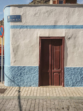 Direct view of brown wooden double door in stucco building