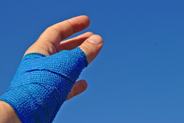 left male hand with a blue elastic bandage