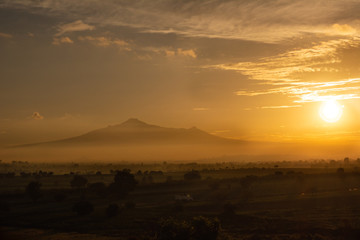 Hermoso atardecer en la montaña, con el sol escondiéndose en el horizonte. 