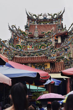 Ornate pagoda with sunshades in foreground, Taiwan