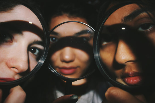 Three faces behind magnifying glasses