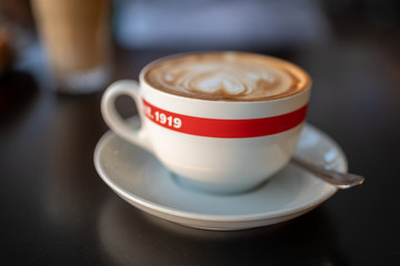 A cup of cappuccino with a spoon