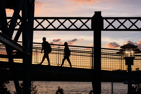 Silhouette of couple walking on bridge