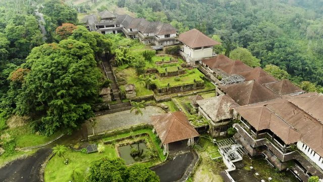 Aerial view Creepy slow motion footage of the abandoned Ghost Palace Hotel in Bali, surrounded by a dense fog