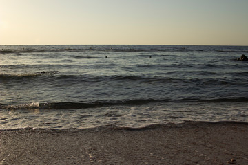 Summer background of hot sand with sea or ocean wave bubbles with copy space for card or advertisement at dawn or sunset