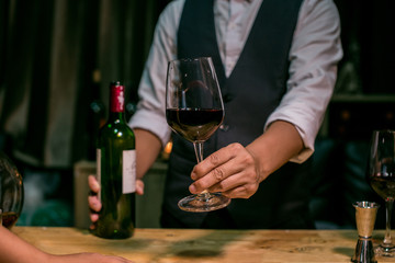 Waitress man pouring wine into glass