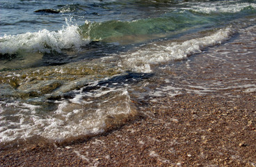 Summer background of hot sand with sea or ocean wave bubbles with copy space for card or advertisement at dawn or sunset