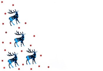 Christmas and New Year background with blue silhouette deer and reds stars confetti. Holiday symbols on white background. Copy space.