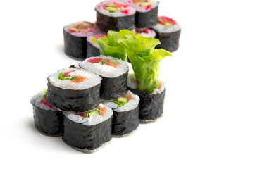 Sushi rolls with green salad on white background