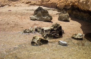 Summer background of hot sand with sea or ocean wave bubbles with copy space for card or advertisement at dawn or sunset