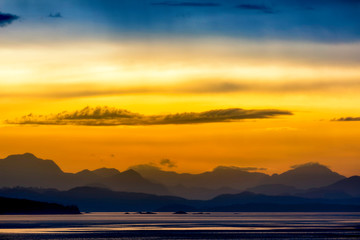 Fototapeta na wymiar Silhouetted Mountains at Sunset at Coastline