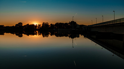 Fototapeta premium Beautiful sunset with reflections in the river Isar near Plattling, Bavaria, Germany