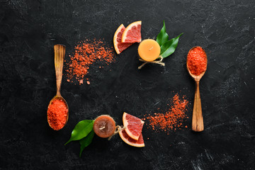 Orange sea salt in wooden spoons. Spa treatments. Top view. Free copy space.