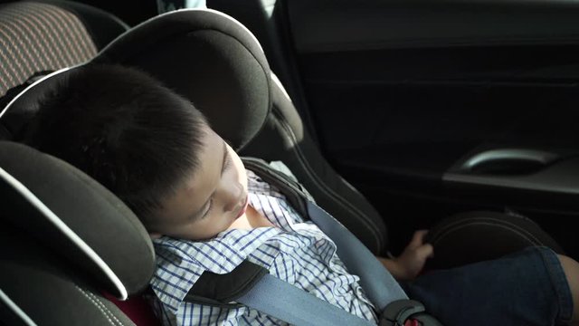 Asian boy about 3 year and 8 months sleeping in baby car seat while parking