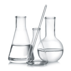 Laboratory glassware with liquid samples on white background