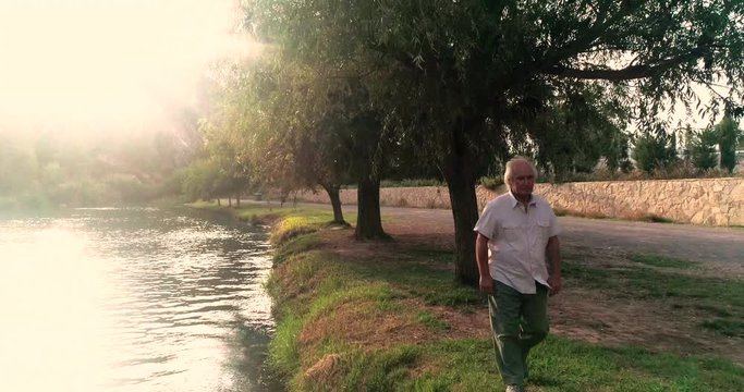 anciano paseando por la orilla del r&iacute;o