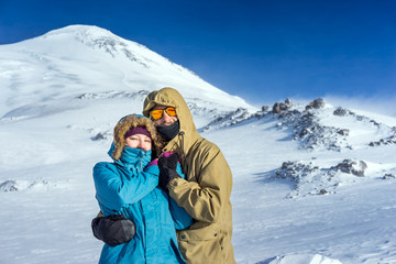 Fototapeta na wymiar Happy young couple snowboarders on the background high mountains on the winter resort