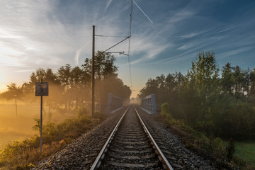 Fototapeta na wymiar Railway track in color morning with fog and autumn color fresh air