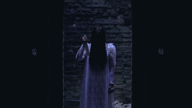 Scary dead bride standing in doorway with sharp knife in hand terrible nightmare