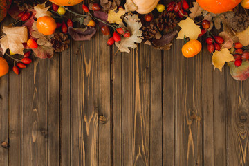 autumn background with colored leaves and pumpkins on wooden board