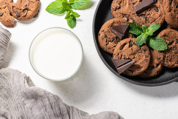 Idea for healthy and tasty breakfast with fresh homemade chocolate cookies and glass of milk.