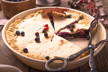 A traditional American blueberry pie on a light background. copy space