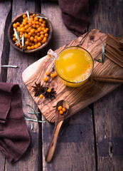 Sea buckthorn tea with orange in a glass cups on wooden table. Herbal vitamin tea..