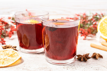 Two glasses of hot aromatic mulled wine with spices and fruits on the table. Traditional festive Christmas drink.