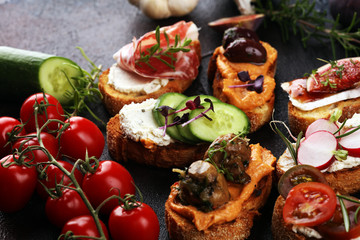 Assorted bruschetta with various toppings. Appetizing bruschetta or brie crostini. Variety of small...