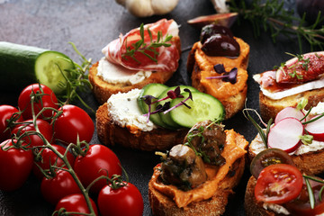 Assorted bruschetta with various toppings. Appetizing bruschetta or brie crostini. Variety of small sandwiches. Mix bruschetta on table
