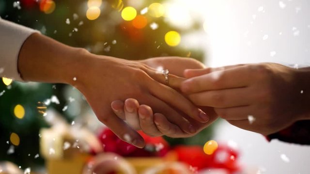 holidays, engagement and proposal concept - hands of engaged couple with diamond ring on christmas