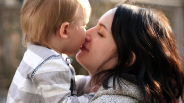 Toddler boy and mother kissing, authentic and genuine love, Close up shot with shallow depth of field