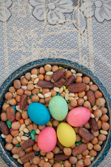 Novruz symbol on xoncha on white background Azerbaijan holiday . There are colored eggs, hazelnuts, dates, and peanuts in the cabin.