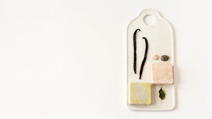 Two Soap from soy wax with vanilla and oliva,sea pebbles on white marble board on white background. Natural cosmetics. Ecological soap, top view, flat lay, overhead