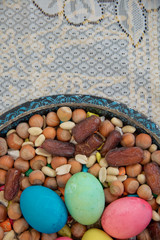 Novruz symbol on xoncha on white background Azerbaijan holiday . There are colored eggs, hazelnuts, dates, and peanuts in the cabin.