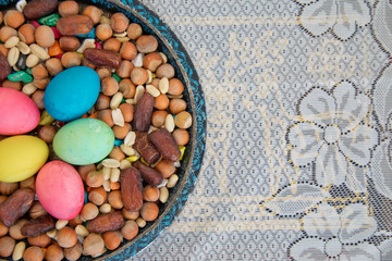 Novruz symbol on xoncha on white background Azerbaijan holiday . There are colored eggs, hazelnuts, dates, and peanuts in the cabin.