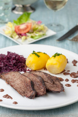 german sauerbraten with red cabbage on a plate