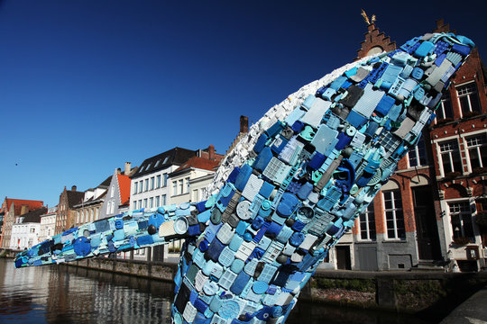 Editorial image of a life-size whale statue made of blue plastic waste (denouncing the plastic pollution omnipresent in the environment) - circa 2018 - Bruges, Belgium