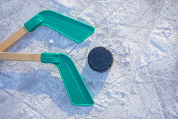 Ice hockey stick and puck on ice.equipment for hockey player in winter game season.Winter sport game for children. Activity games outdoor in winter.