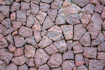 the old fortress wall of red marble stones of various shapes and sizes. rough surface texture