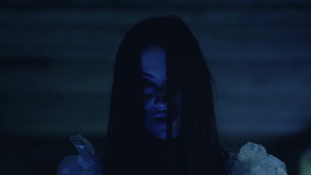 Evil grin on witch face in darkness, black magic ritual, supernatural power