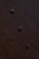fragment of a rusty metal floor with large rivets