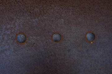 fragment of a rusty metal floor with large rivets