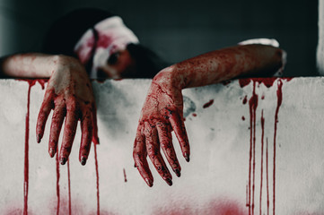 Horror Scene of a Woman bloody hands with resentment torture and ask for help, in abandoned building, Halloween murder concept.