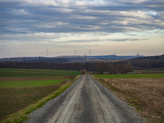 Fototapeta na wymiar Country road and agriculture fields on cloudy day