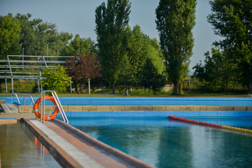 Swimmer standing next to a pool on a sunny morning