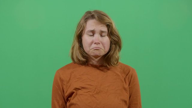 Facial Expression Of A Woman Pouting. Studio Isolated Shot Against Green Screen Background